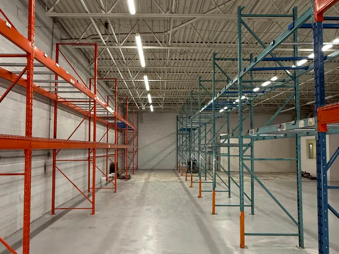 Orange and teal pallet racking with beams and wire decks, put back up at the new location