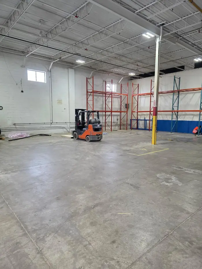 A forklift beside new racking in a warehouse