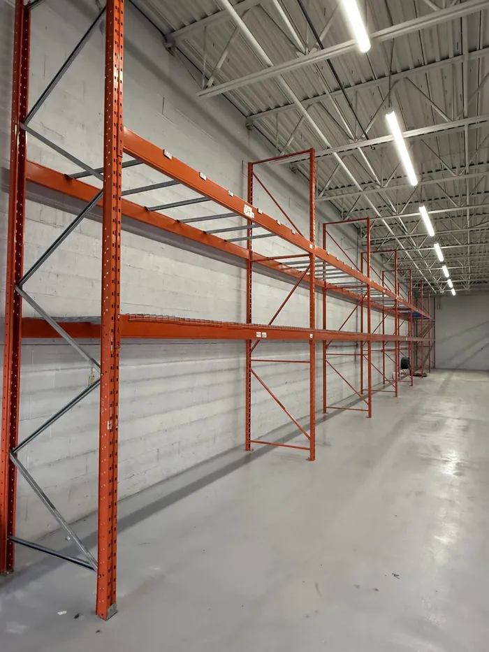 A run of orange racking along a white wall