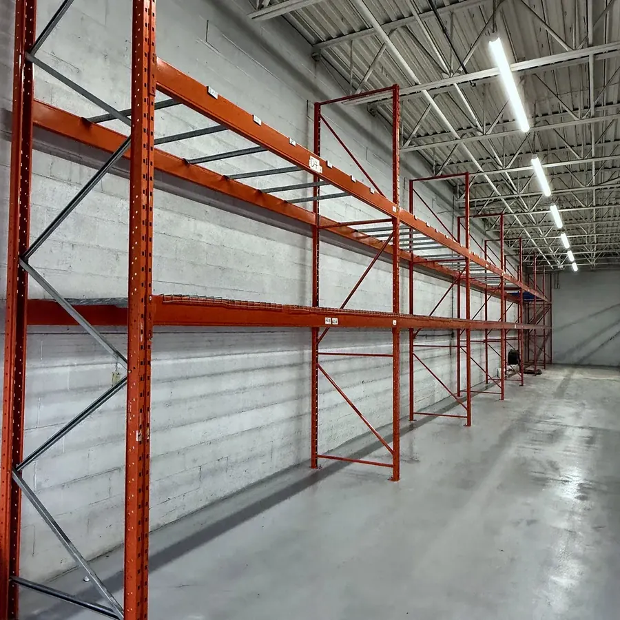 A run of orange pallet racking in an empty warehouse
