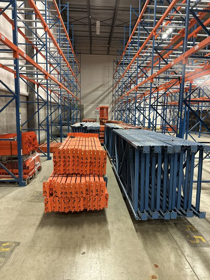 Beams and frames laid in a warehouse aisle during a tear-down