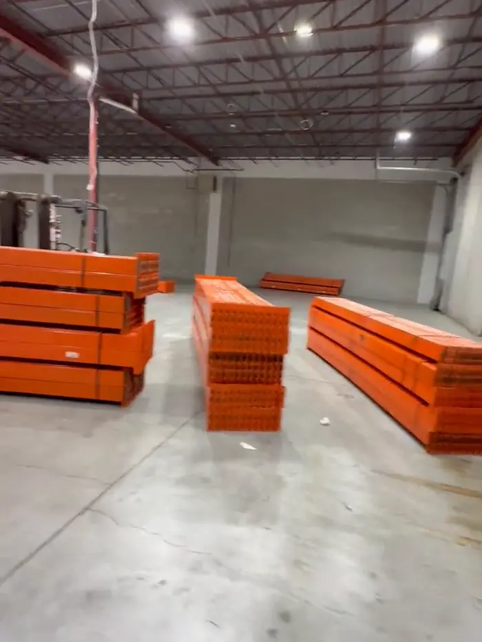 Orange beams stacked in bundles on a clear floor