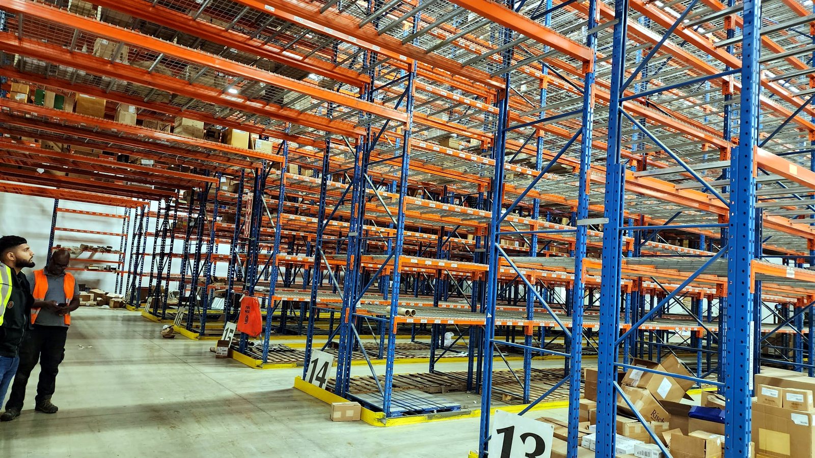 Two 416 crew members reviewing a fresh selective pallet racking install at aisles 13 and 14 in a GTA warehouse