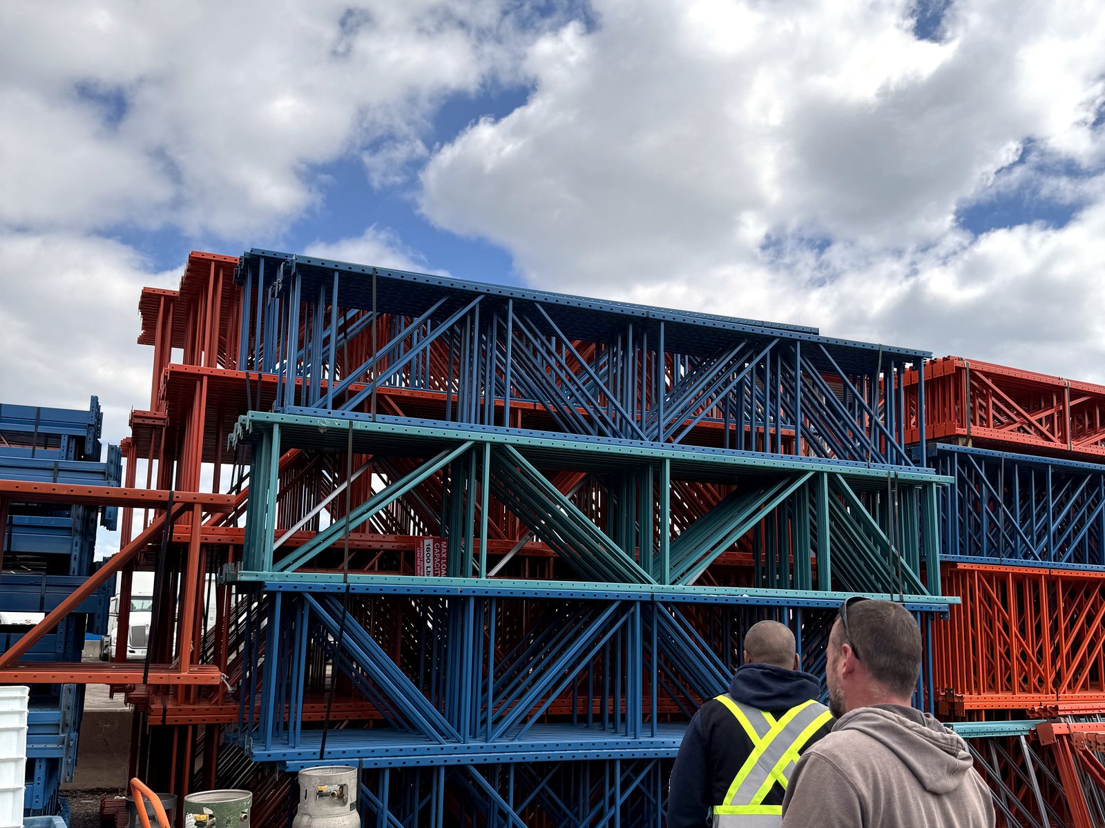 Two 416 crew members in the yard with stacked pallet racking frames from GTA buy-backs and teardowns