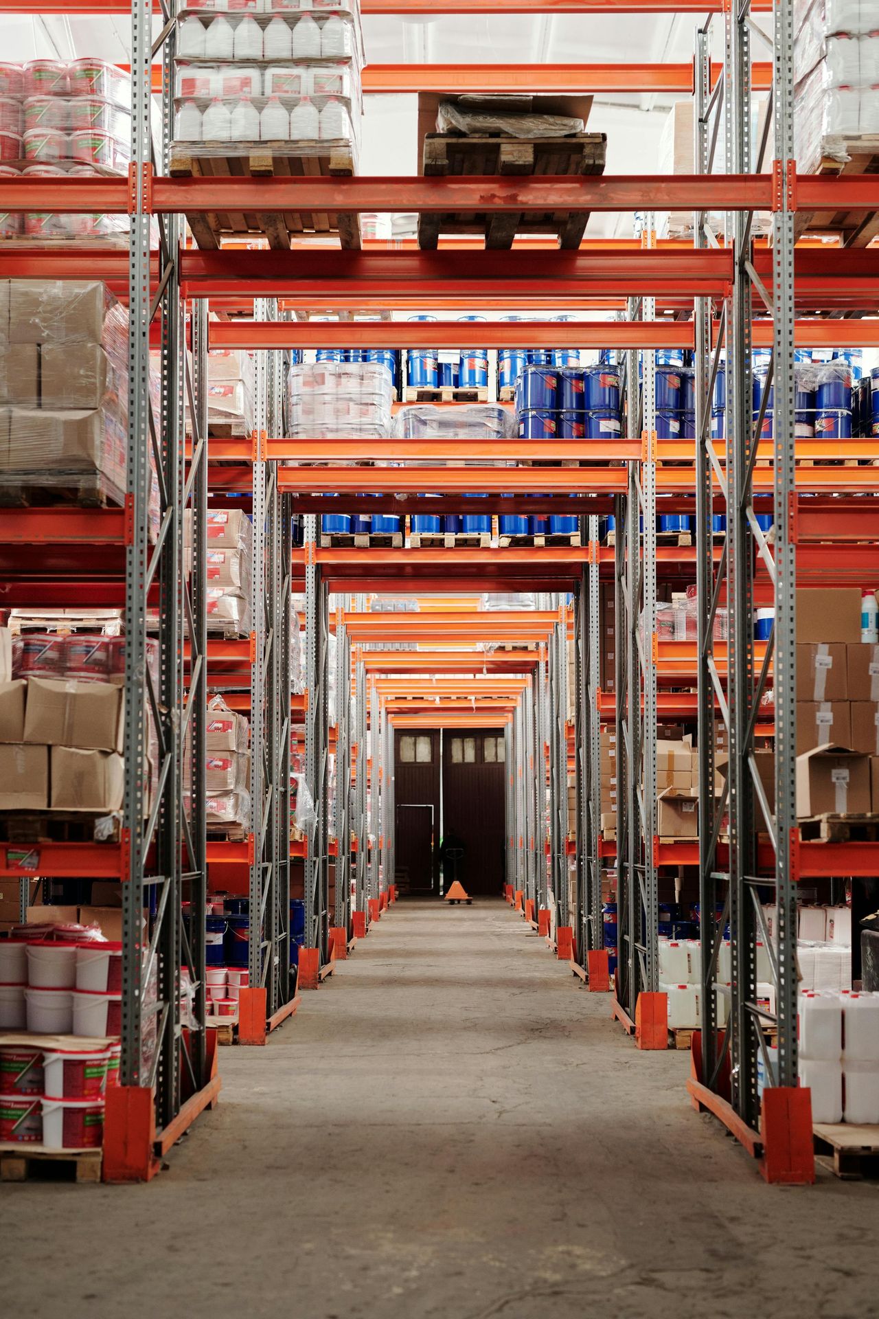 Orange pallet racking aisle during an annual rack-safety inspection (illustrative)