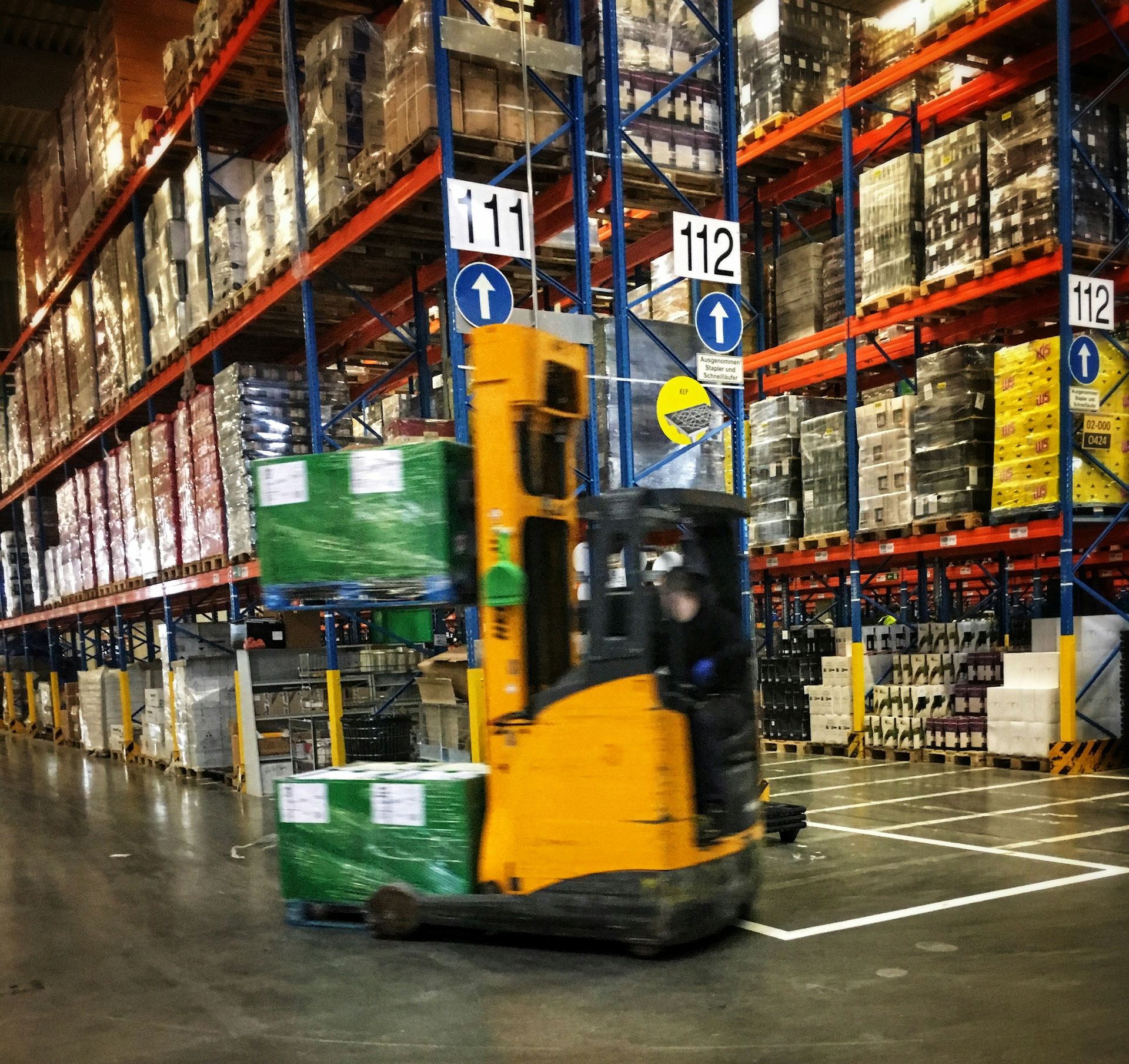 Reach truck moving through a warehouse racking aisle