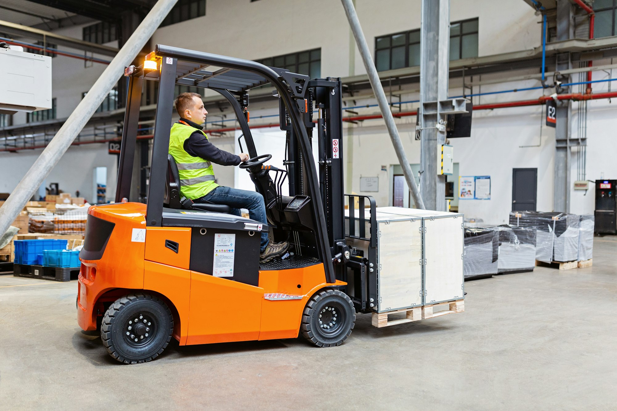 Storehouse employee in uniform working on forklift in modern automatic warehouse